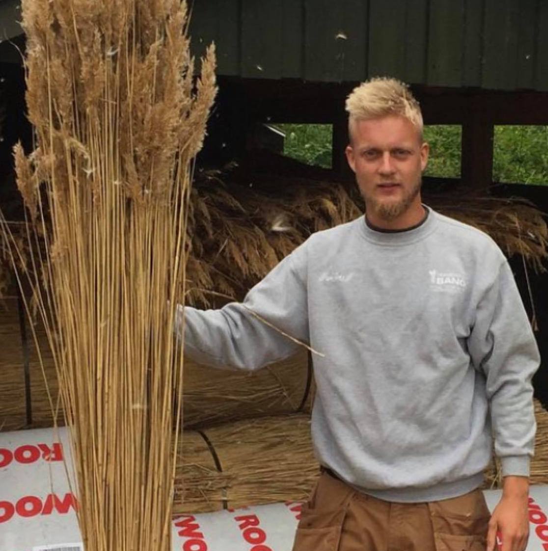 Tækkemand Jonas Palm fra Odense, som står med strå til stråtag